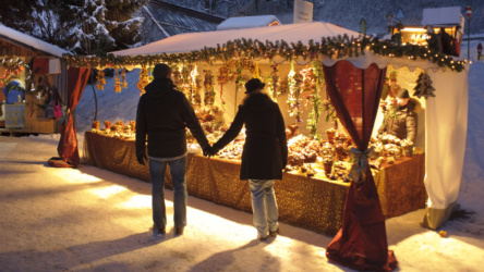 Weihnachtsmarkt mit romantisch beleuchteten Holzhütten